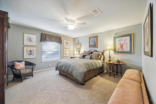 bedroom with a textured ceiling, ceiling fan, and light colored carpet