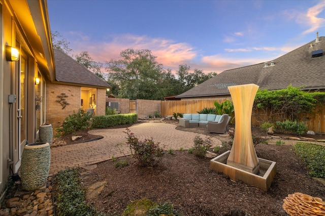 yard at dusk featuring a patio area and an outdoor hangout area