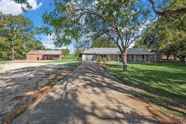 ranch-style house featuring covered porch, a garage, and a front lawn