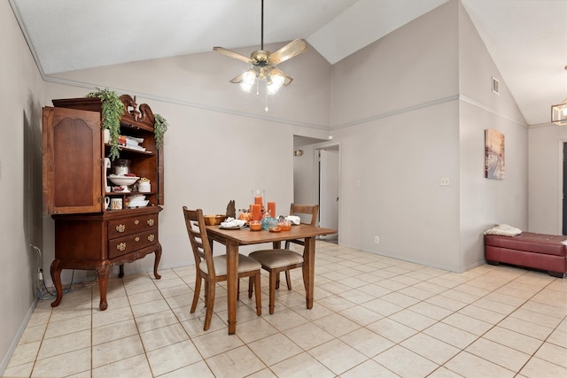 tiled dining space with ceiling fan and high vaulted ceiling