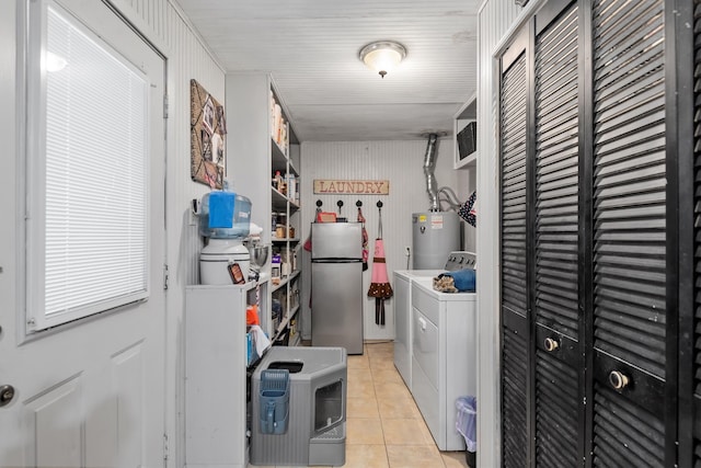 washroom with washer and dryer, gas water heater, and light tile patterned flooring