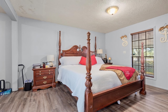 bedroom with a textured ceiling and hardwood / wood-style flooring