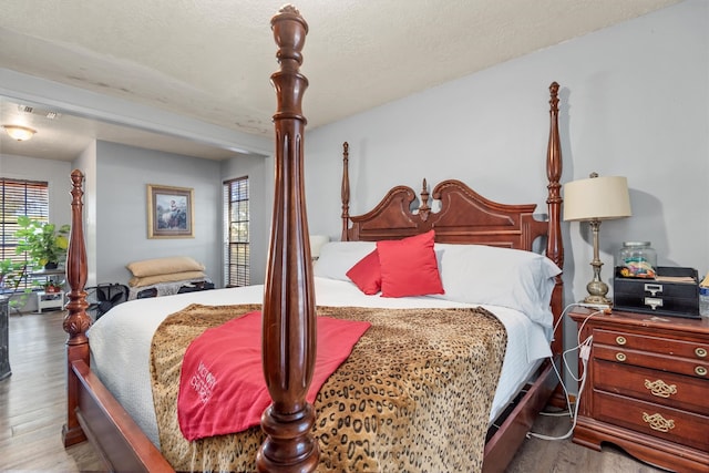 bedroom featuring wood-type flooring and a textured ceiling