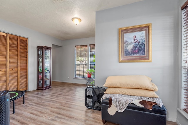 sitting room featuring a textured ceiling and light wood-type flooring