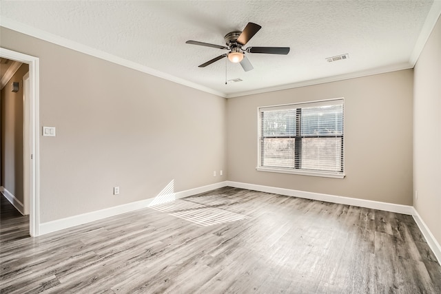 empty room featuring a textured ceiling, ceiling fan, wood-type flooring, and crown molding