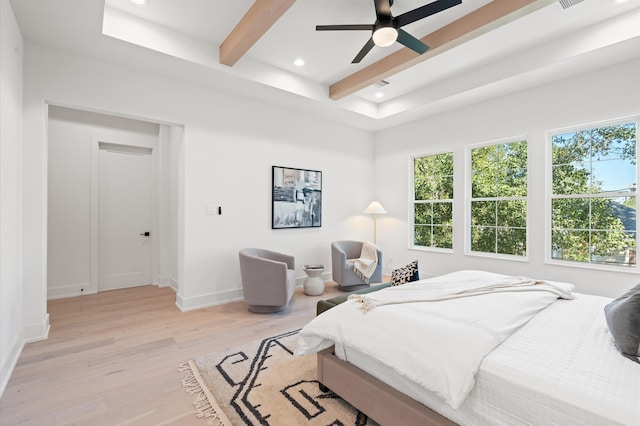 bedroom with ceiling fan, beamed ceiling, and light hardwood / wood-style floors