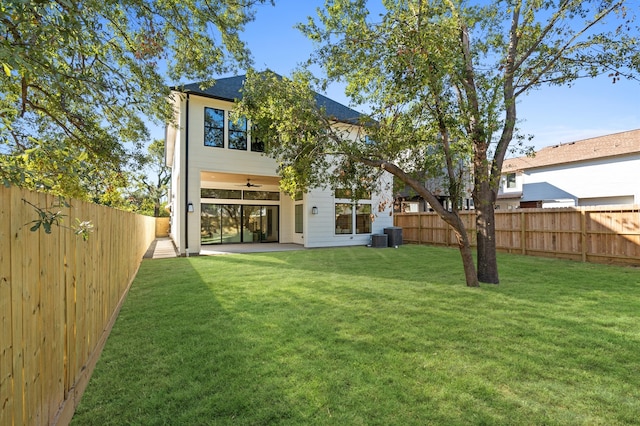 rear view of house with a yard, ceiling fan, and a patio area