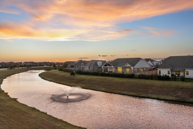 view of home's community with a lawn and a water view