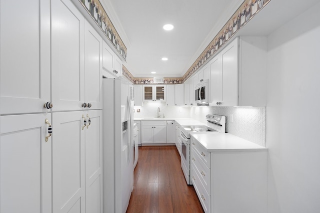 kitchen with white appliances, dark wood-type flooring, white cabinets, decorative backsplash, and ornamental molding