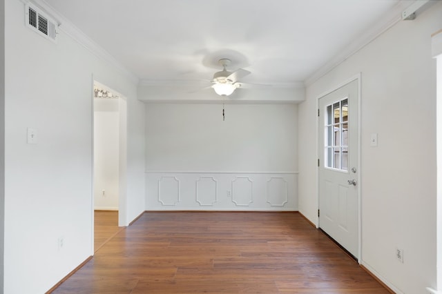 empty room with ceiling fan, dark hardwood / wood-style flooring, and ornamental molding