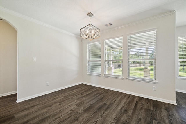 spare room with an inviting chandelier, ornamental molding, and dark hardwood / wood-style flooring