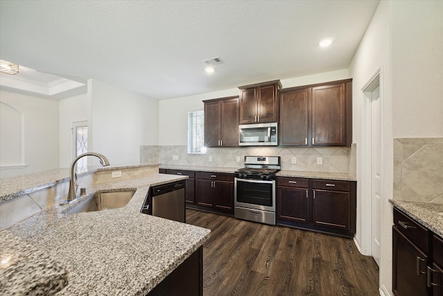 kitchen with dark wood-type flooring, sink, dark brown cabinets, light stone counters, and stainless steel appliances