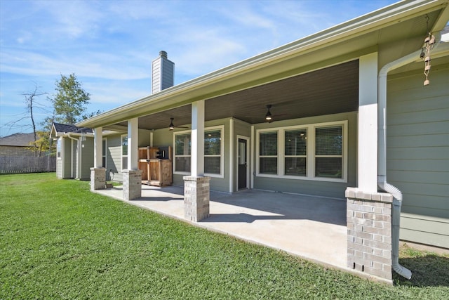 rear view of house with a lawn, ceiling fan, and a patio area