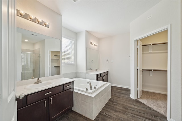 bathroom with hardwood / wood-style floors, vanity, and separate shower and tub