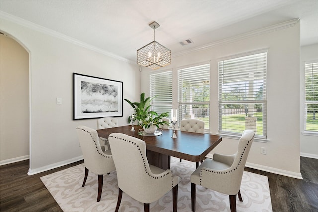 dining room with ornamental molding, dark hardwood / wood-style floors, and a chandelier