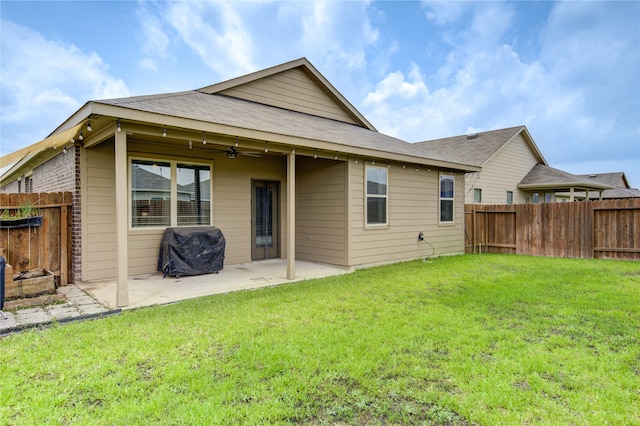 back of property with a lawn and a patio area