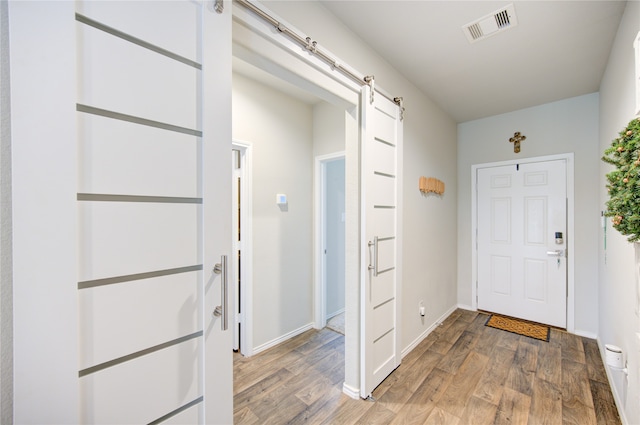 foyer entrance featuring a barn door and wood-type flooring