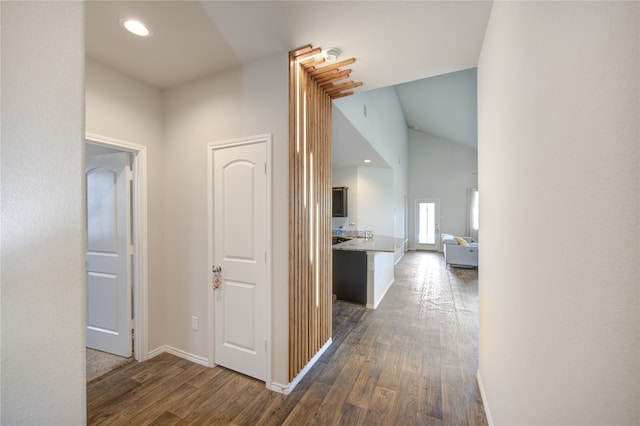 corridor featuring vaulted ceiling and dark hardwood / wood-style floors