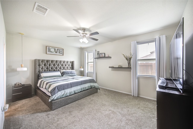 carpeted bedroom featuring multiple windows and ceiling fan