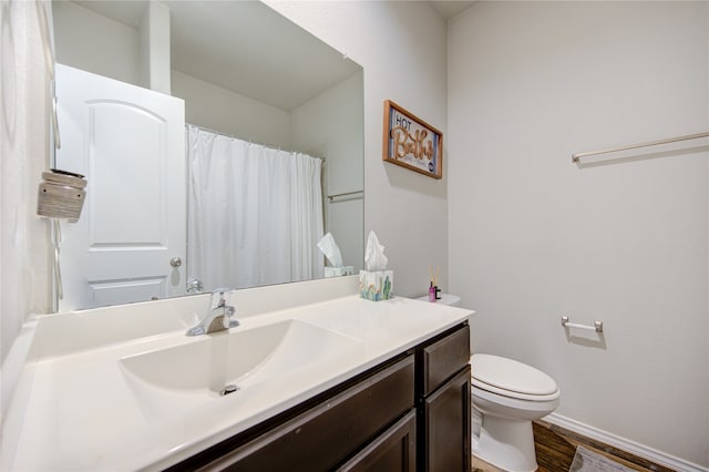 bathroom with hardwood / wood-style floors, vanity, and toilet