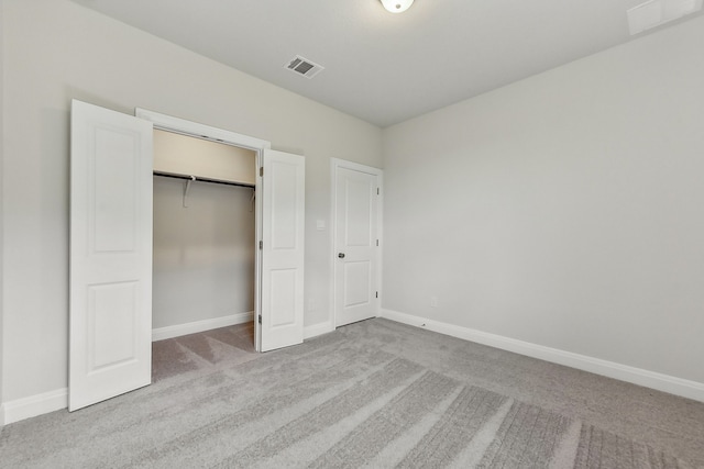 unfurnished bedroom with light colored carpet and a closet