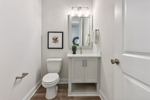 bathroom with vanity, hardwood / wood-style flooring, and toilet