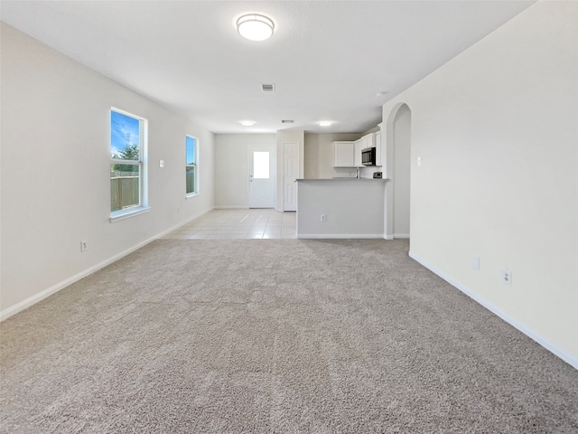 unfurnished living room featuring light colored carpet