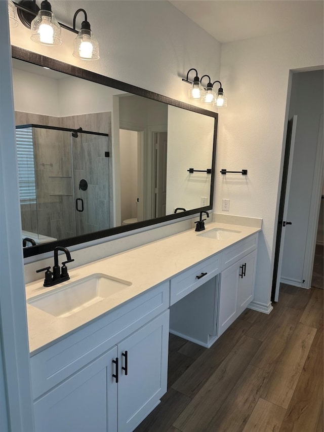 1253 Woodflower Dr, Katy, TX 77493 - full bath with double vanity, a shower stall, wood finished floors, and toilet