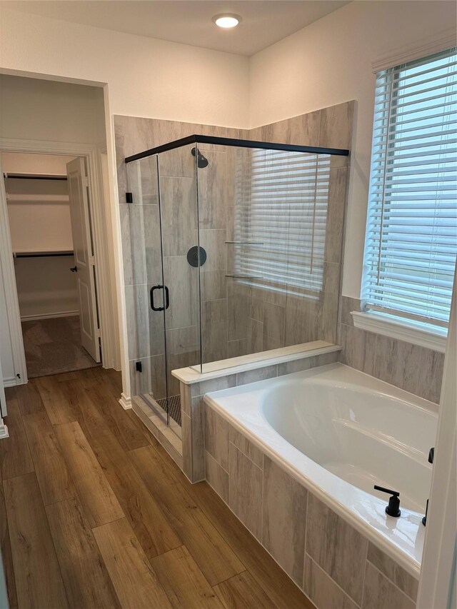 1253 Woodflower Dr, Katy, TX 77493 - bathroom with a garden tub, a stall shower, wood finished floors, and a walk in closet