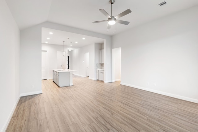 unfurnished living room with ceiling fan, light hardwood / wood-style flooring, lofted ceiling, and sink