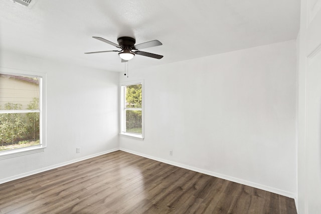 unfurnished room with dark hardwood / wood-style flooring, ceiling fan, and a healthy amount of sunlight