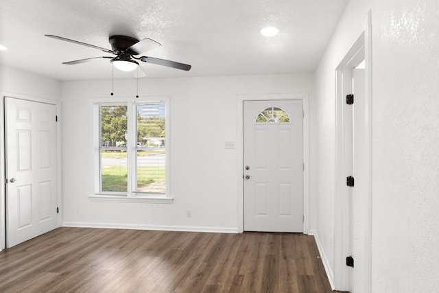 entrance foyer with ceiling fan, dark wood-type flooring, and a textured ceiling