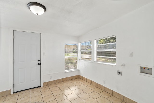 interior space with light tile patterned flooring and vaulted ceiling