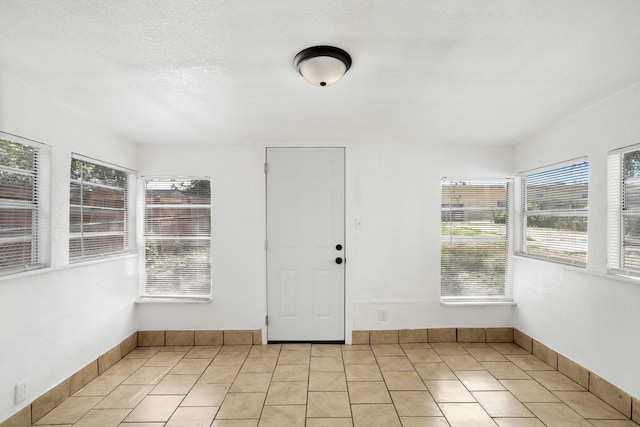 interior space featuring light tile patterned floors and a textured ceiling