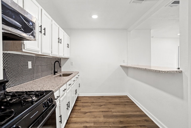 kitchen with white cabinetry, sink, light stone countertops, tasteful backsplash, and dark hardwood / wood-style floors