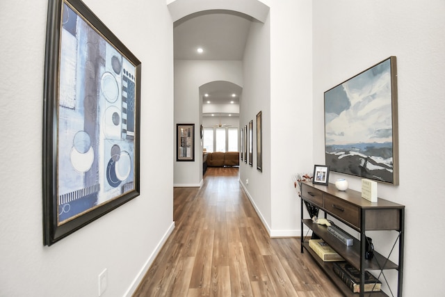 hallway with hardwood / wood-style floors and a high ceiling