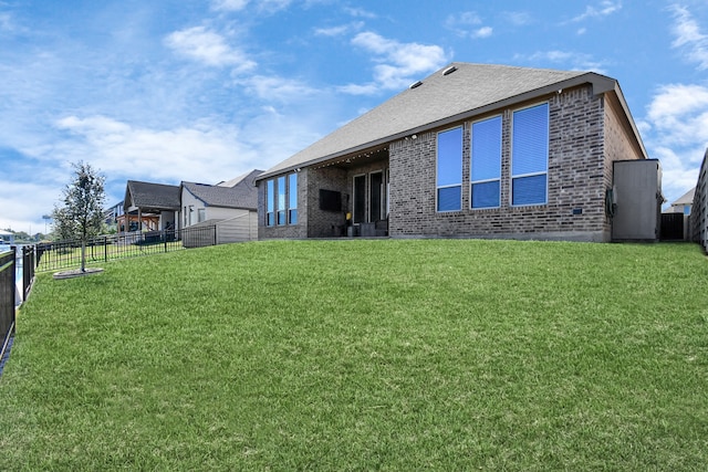 rear view of property featuring a lawn