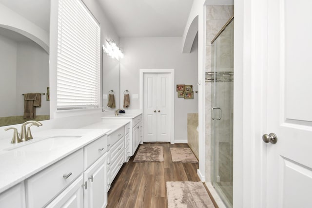 bathroom with vanity, wood-type flooring, and walk in shower