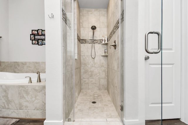 bathroom featuring shower with separate bathtub