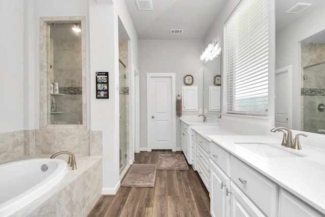 bathroom featuring vanity, wood-type flooring, and shower with separate bathtub