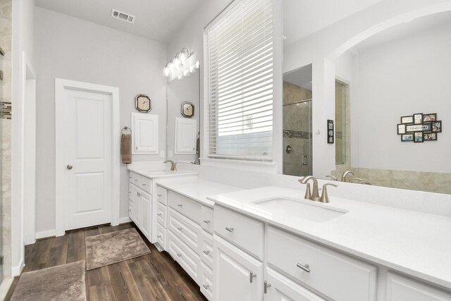 bathroom with hardwood / wood-style floors, vanity, and an enclosed shower