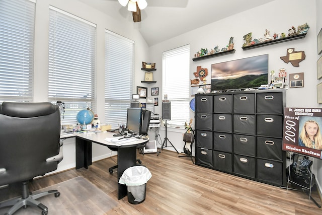 office featuring wood-type flooring, vaulted ceiling, ceiling fan, and a healthy amount of sunlight