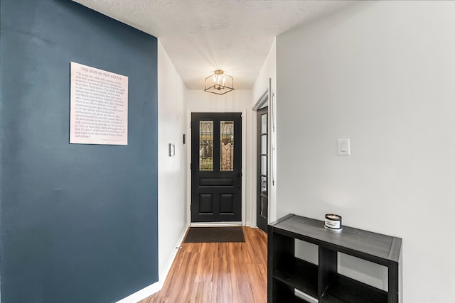 interior space with hardwood / wood-style floors, a textured ceiling, and an inviting chandelier