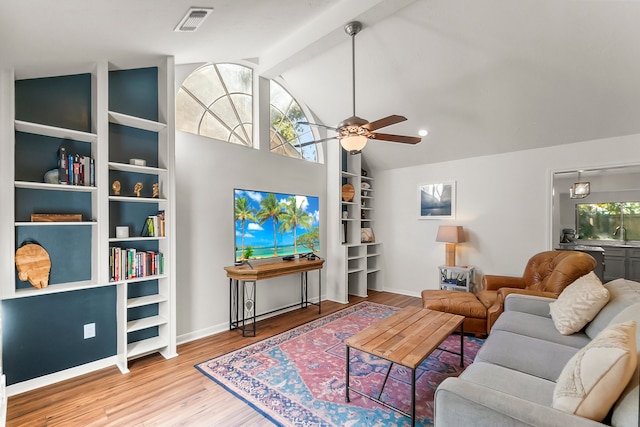 living room with lofted ceiling with beams, light hardwood / wood-style flooring, ceiling fan, and a healthy amount of sunlight