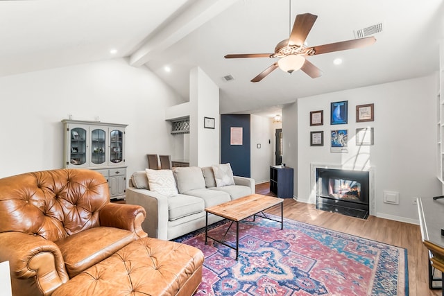 living room featuring lofted ceiling with beams, ceiling fan, and wood-type flooring