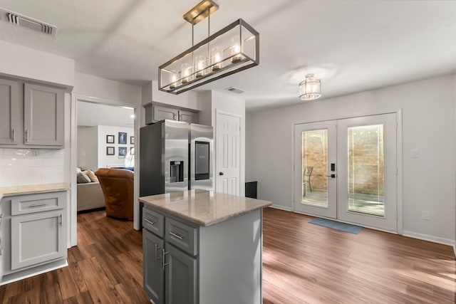 kitchen featuring pendant lighting, dark hardwood / wood-style floors, a center island, and decorative backsplash