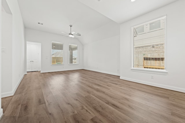 unfurnished living room featuring visible vents, a ceiling fan, wood finished floors, baseboards, and vaulted ceiling