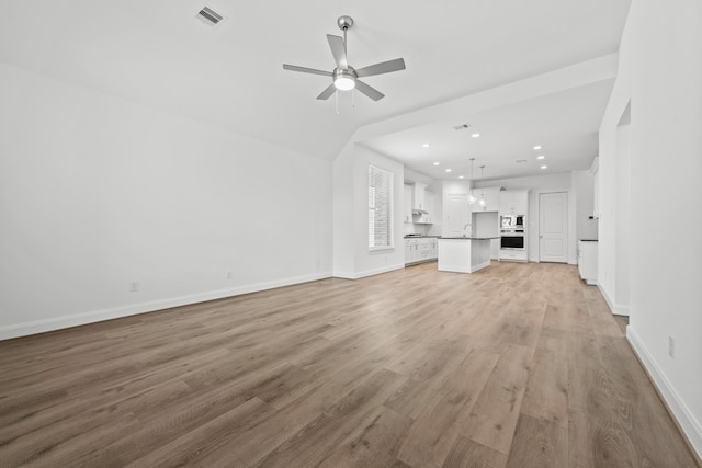 unfurnished living room featuring light wood-type flooring, visible vents, a ceiling fan, recessed lighting, and baseboards