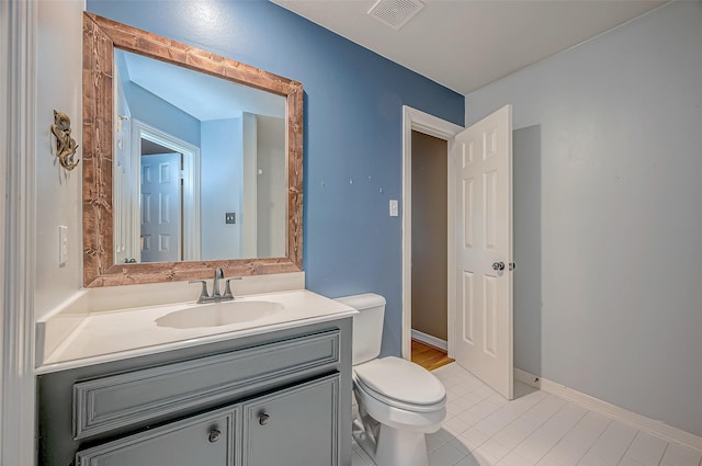 bathroom featuring tile patterned flooring, vanity, and toilet