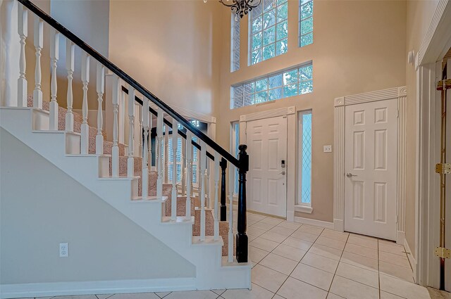 tiled foyer with a notable chandelier and a high ceiling